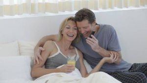 ベッドで笑う夫婦